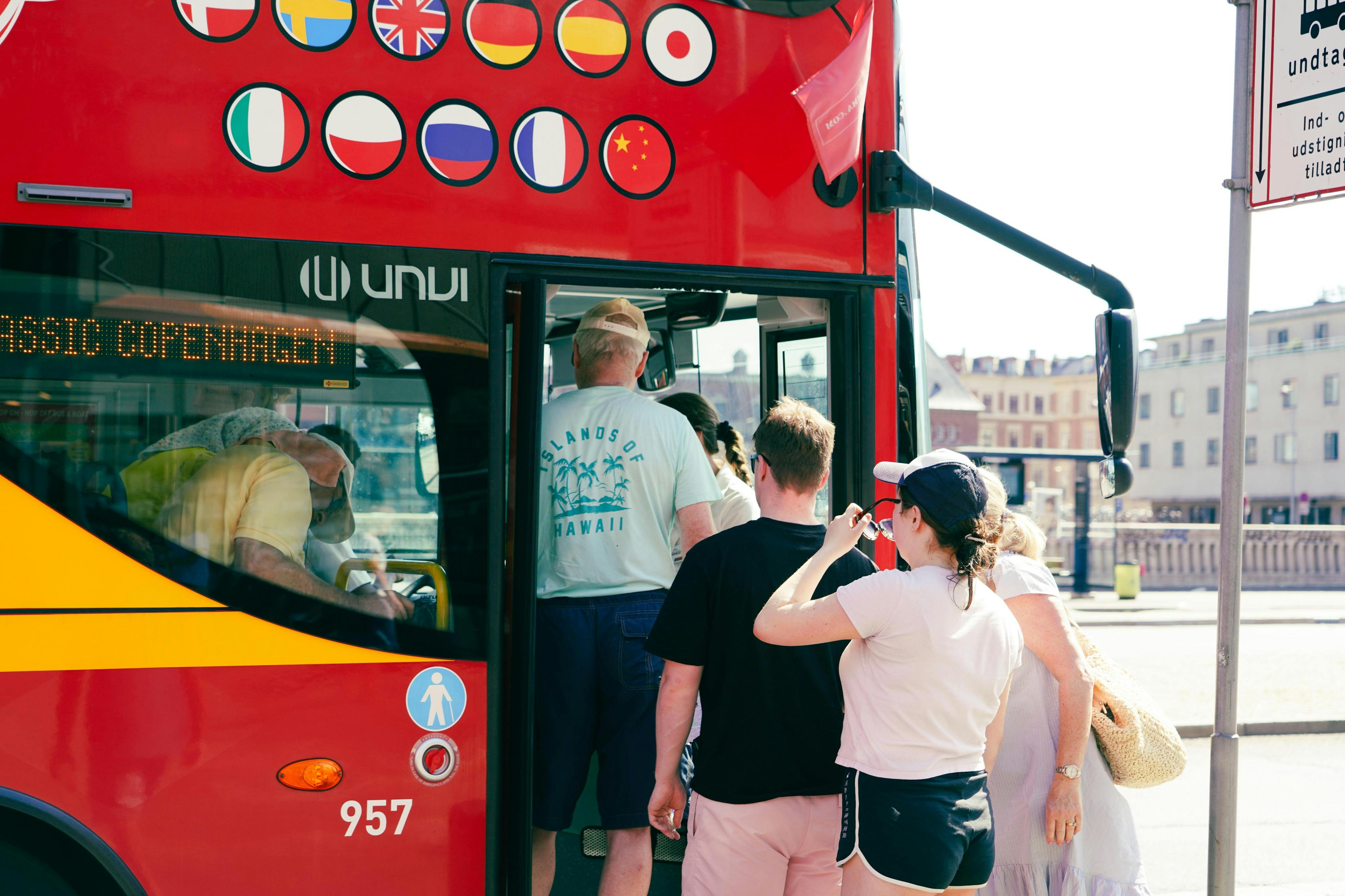 Guests getting on a red Hop On-Hop Off bus in Copenhagen.
