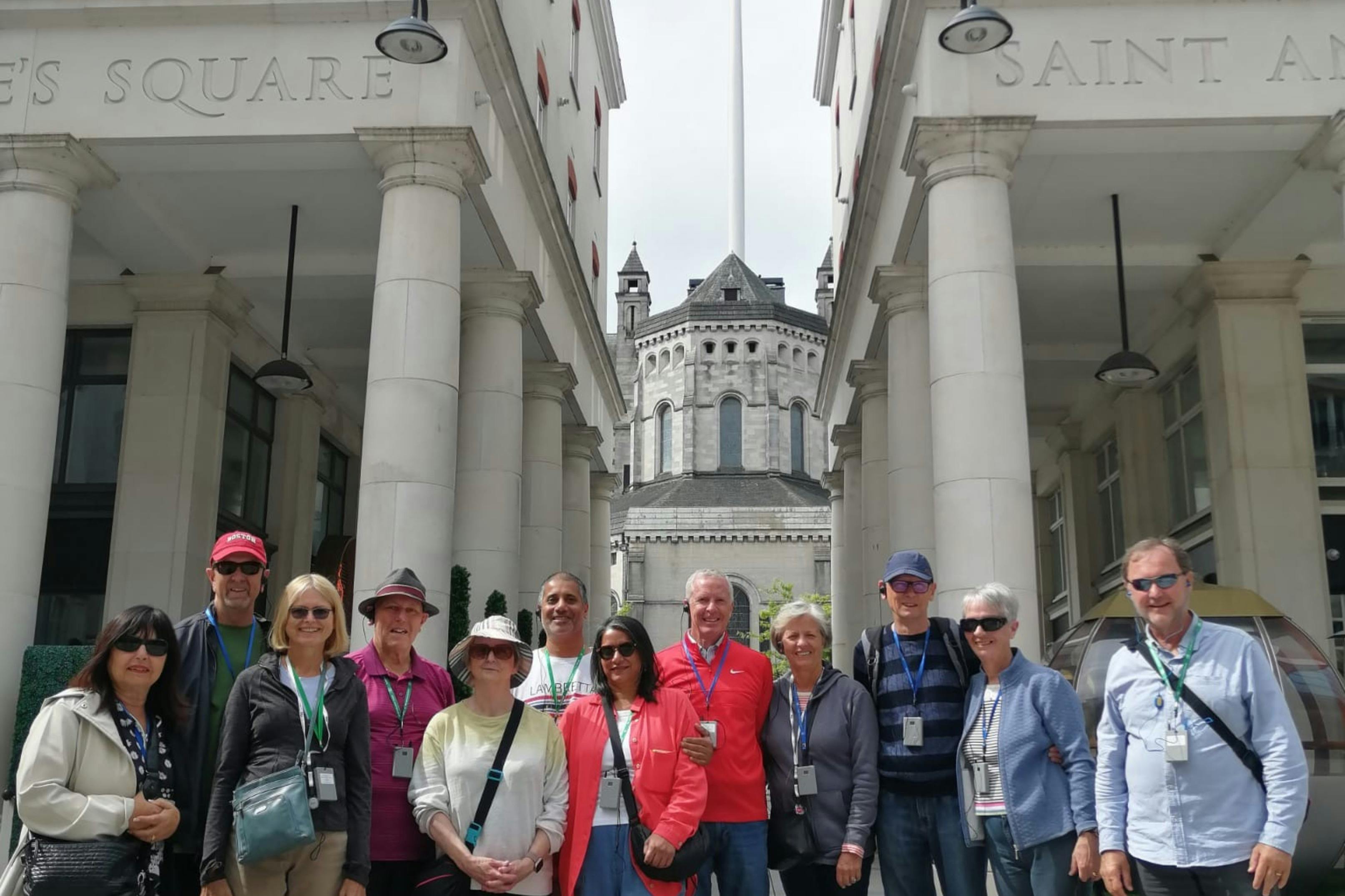 Un groupe de personnes se tenant devant un bâtiment portant le nom de "Sainte Anne", avec une église à l'arrière-plan.