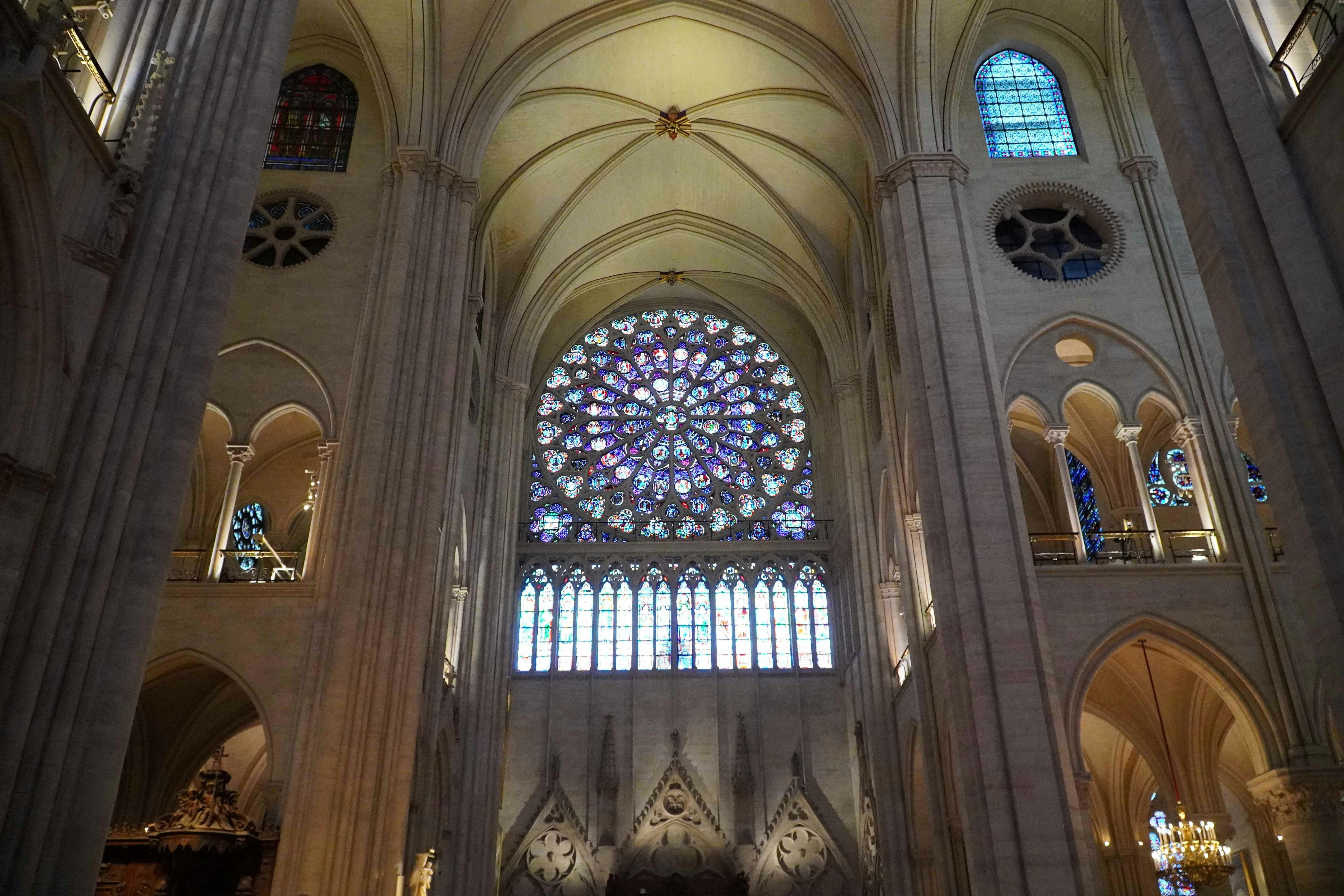 大教堂的内部景观展示了一个巨大而复杂的彩色玻璃玫瑰窗和高拱形天花板。