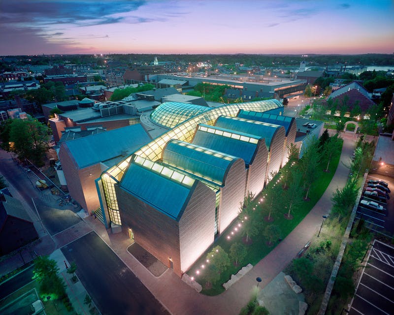 现代化建筑的鸟瞰图，暮光之城的玻璃屋顶是弧形的，周围环绕着城市景观和绿色植物。