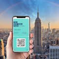 immagine di uno smartphone con un pass per New York e l'Empire State Building e New York sullo sfondo