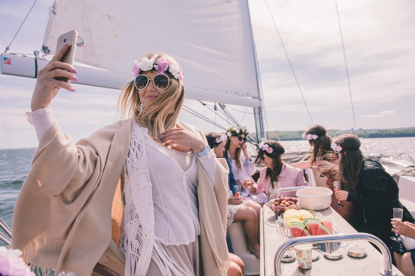 Un groupe de femmes portant des couronnes s'amusant sur un yacht moderne