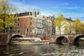 Κρουαζιέρα στα κανάλια του Άμστερνταμ κάτω από μια γέφυρα