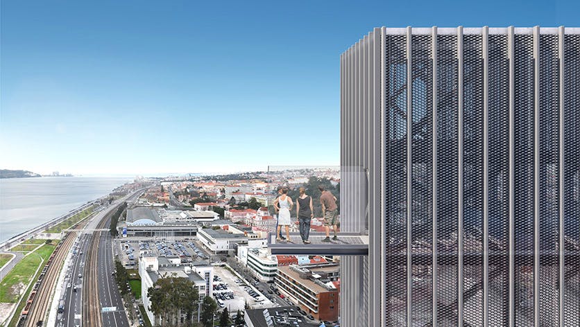 Four people stand on a glass observation deck extending from a tall building, overlooking a cityscape with a clear blue sky.