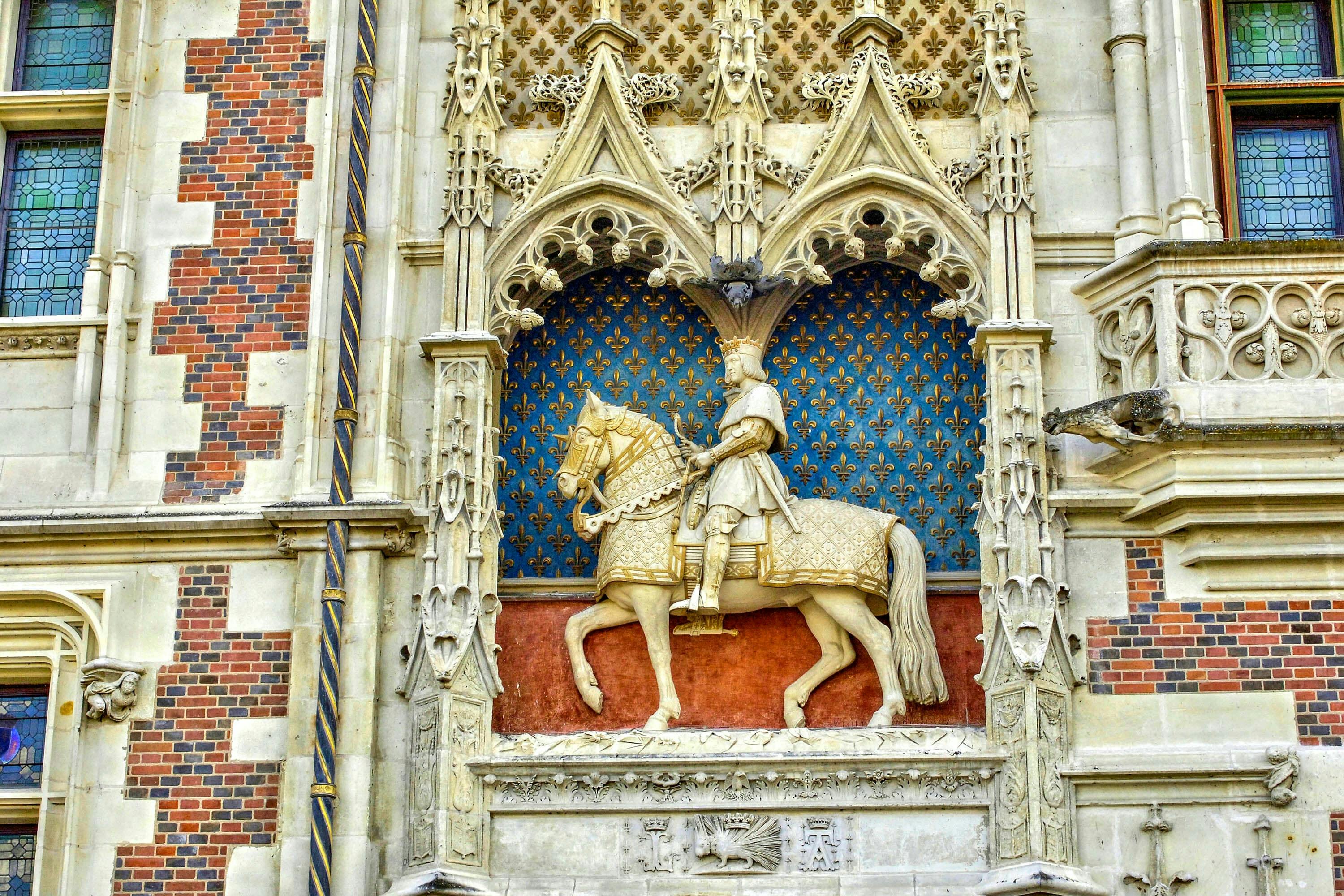 파란색 무늬를 배경으로 정교한 디테일이 돋보이는 고딕 스타일의 틈새시장에서 승마를 즐기는 남자의 화려한 석상.