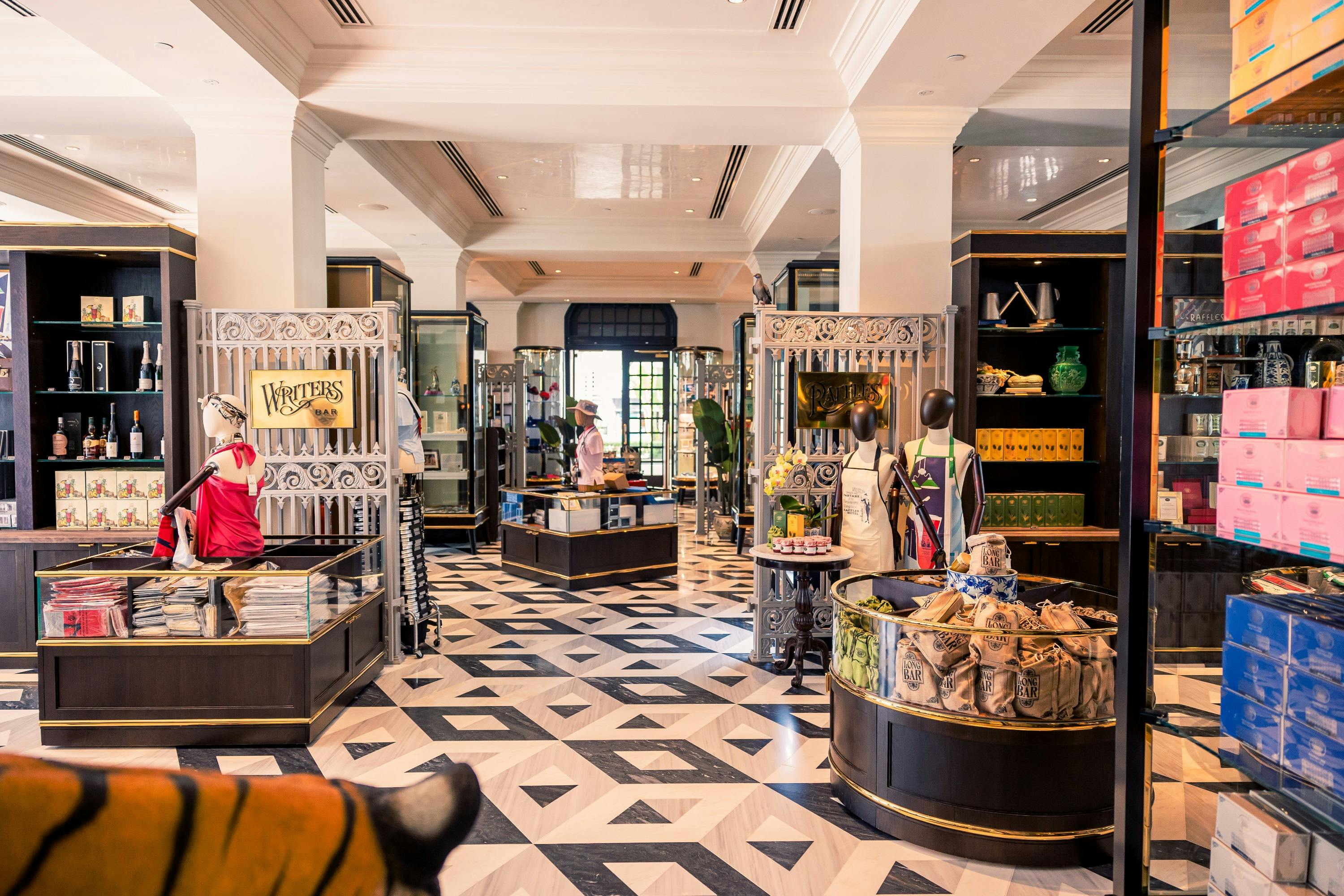 A stylish store interior with geometric black-and-white flooring, decorative shelves, and various items on display.