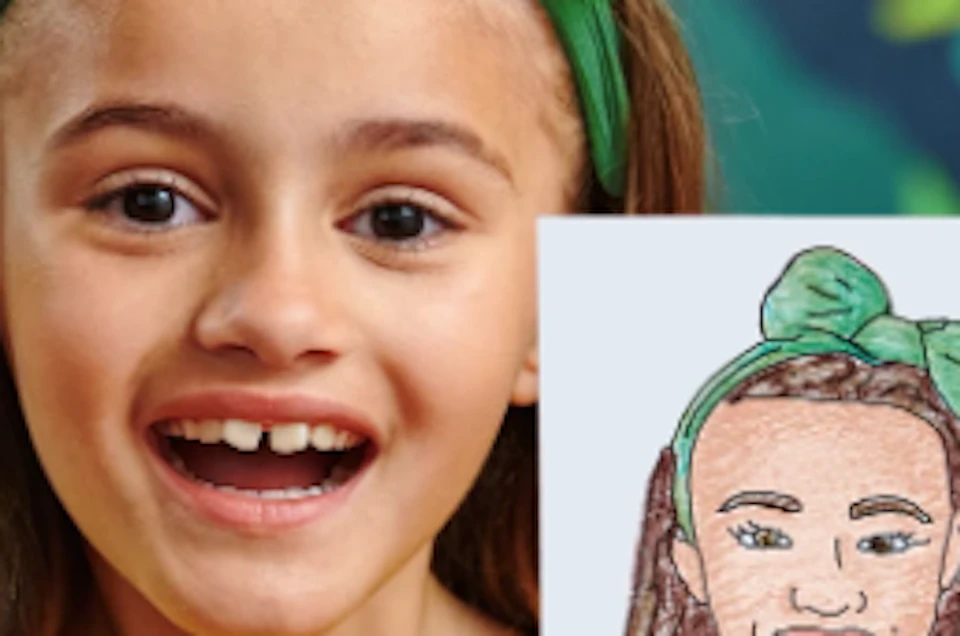 A smiling child in a yellow shirt and green bow holds a personalized drawing of herself at the Crayola Experience.