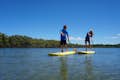 A teacher guiding a paddleboarder down the river