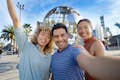 Turistas tirando uma selfie em frente ao globo da Universal na entrada do Universal Studios Hollywood