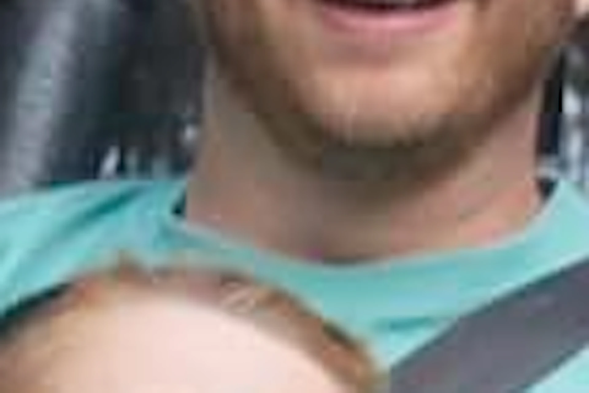 A man and child ride together on a roller coaster through a wooded area, both appearing excited and smiling.