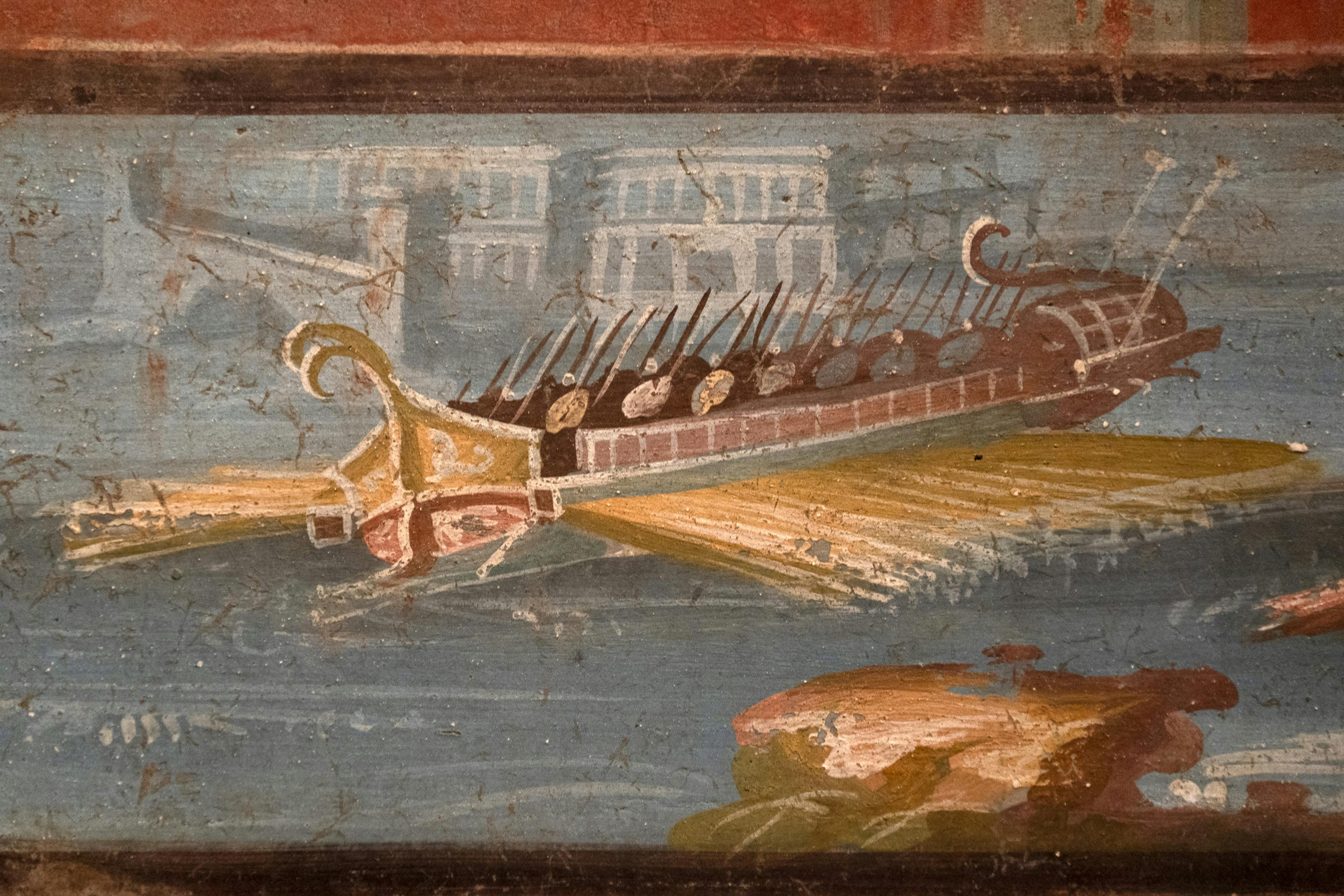 ローマの軍艦を描いた古代のフレスコ画。水上を航行し、建物を背景にして右側に着陸しています。