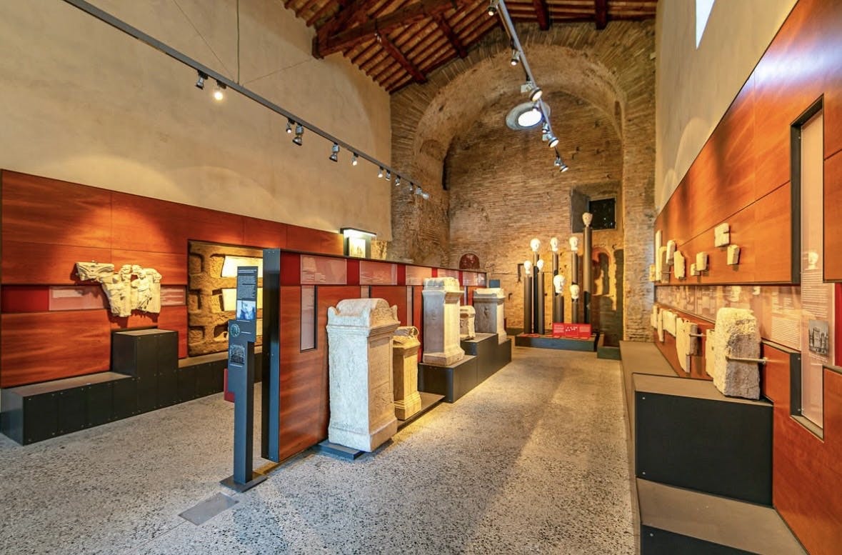 A fresco depicts a central seated figure with a halo, flanked by two standing figures, surrounded by smaller figures and a lamb.