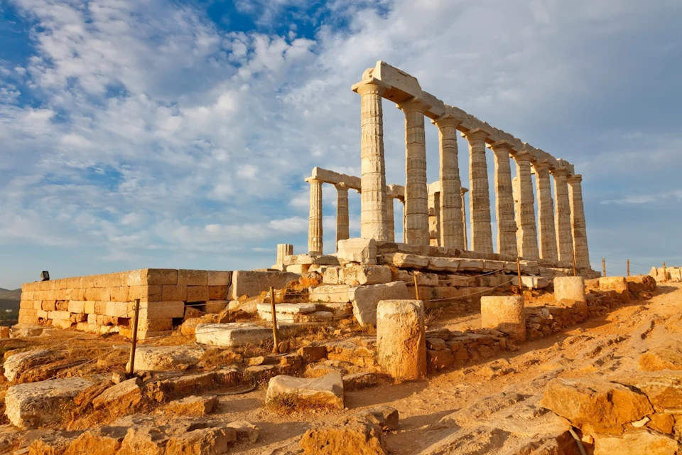 Golden hour light on Temple of Poseidon ruins.
Ancient stone columns and ruins glow in warm afternoon sun.