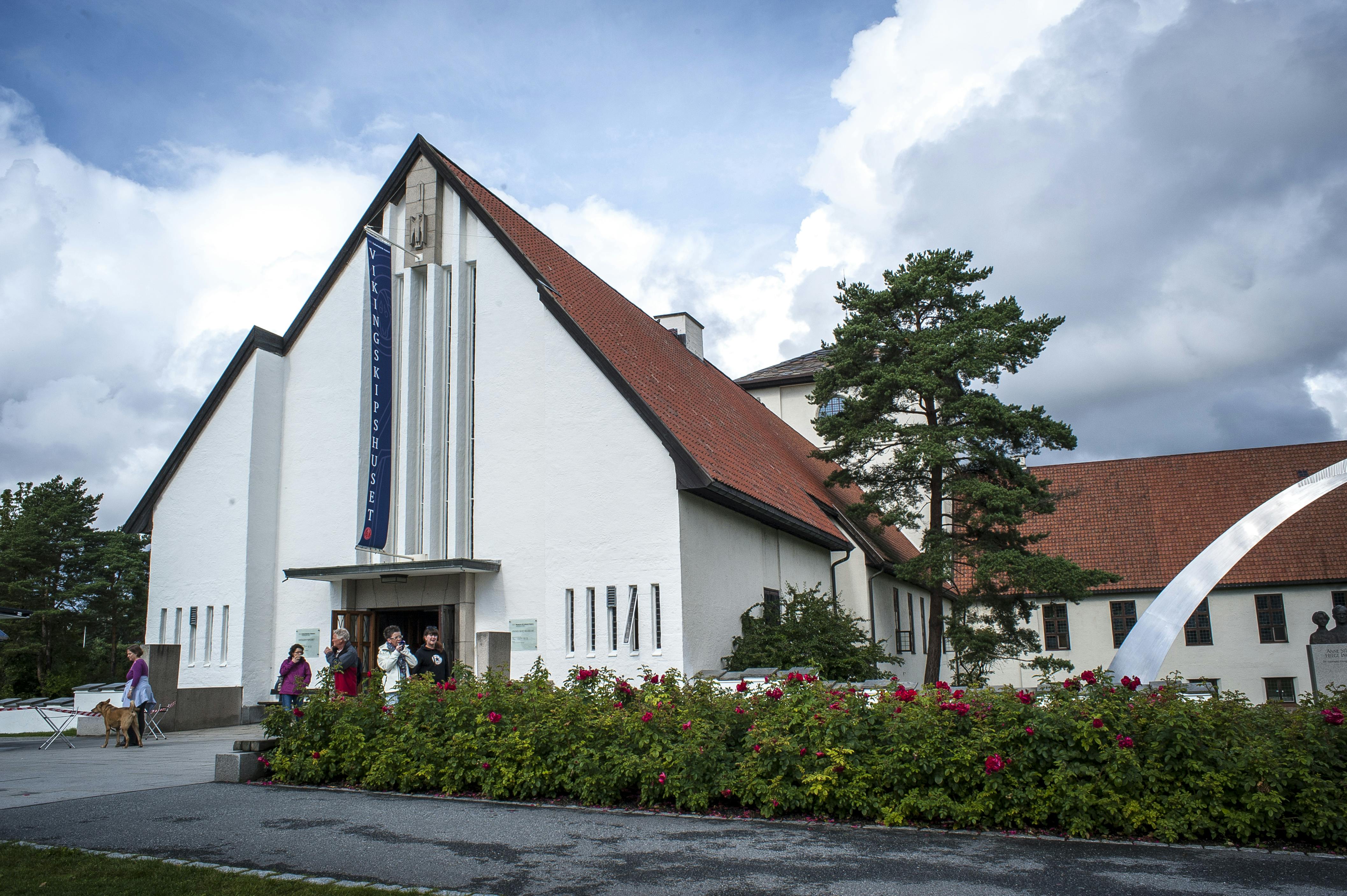 Λευκό εκκλησιαστικό κτίριο με κόκκινη στέγη, λάβαρο «Vigelandmuseet», περιτριγυρισμένο από πράσινο και αρκετά άτομα στην είσοδο.