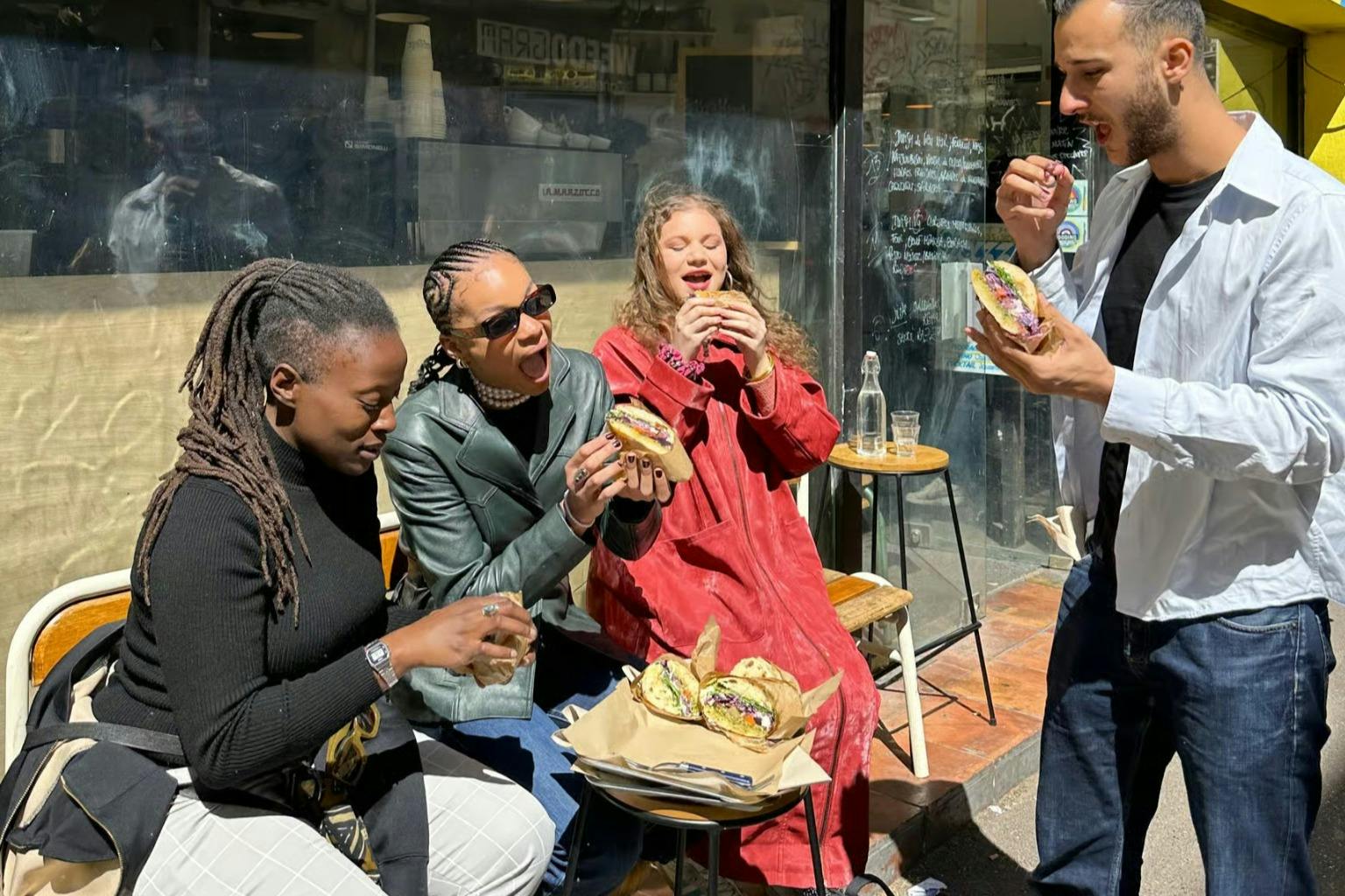 Group of 4 people tasting sandwiches in front of a restaurant in Marseille