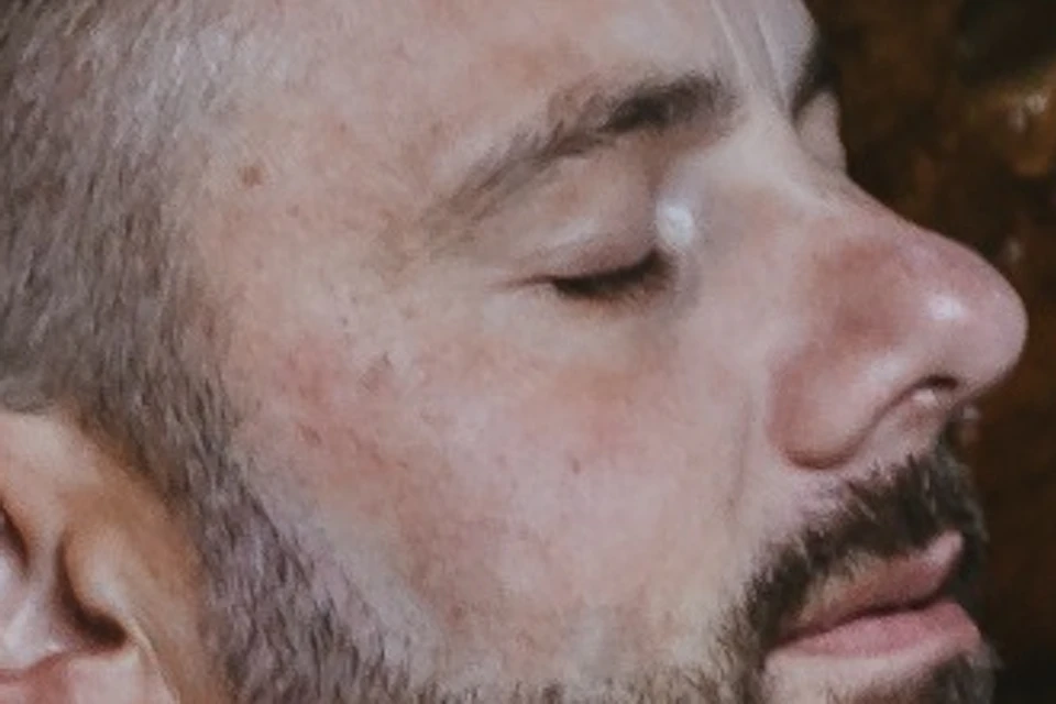 Man looking relaxed and soaking in geothermal waters inside a cave
