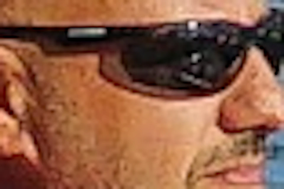 Man in a red polo shirt steering a motor boat