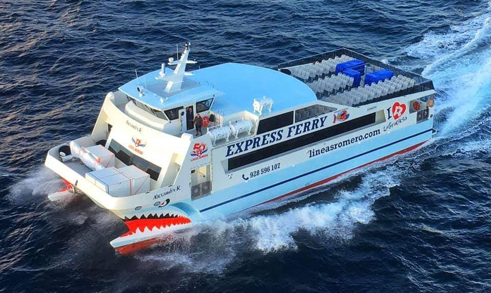 A white ferry named "Alexandre R" from "lineasromero.com" traveling through blue ocean water, with seating visible on the deck.