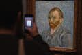 Someone taking a photo of Vincent van Gogh's self-portrait at the Musée d'Orsay
