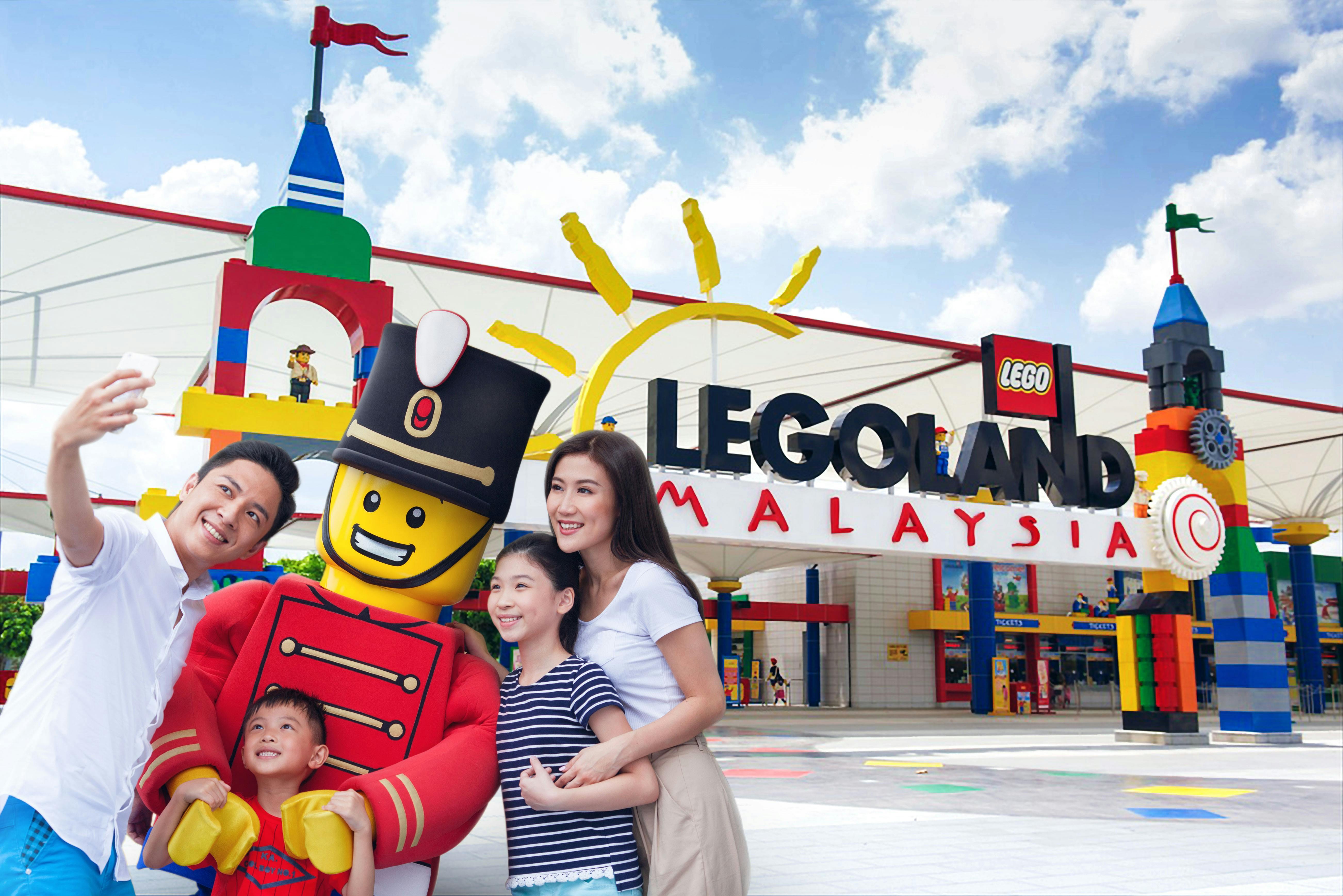 A family poses for a selfie with a large LEGO toy soldier at the entrance of LEGOLAND Malaysia.