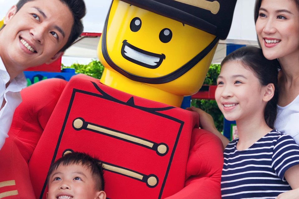A family poses for a selfie with a large LEGO toy soldier at the entrance of LEGOLAND Malaysia.