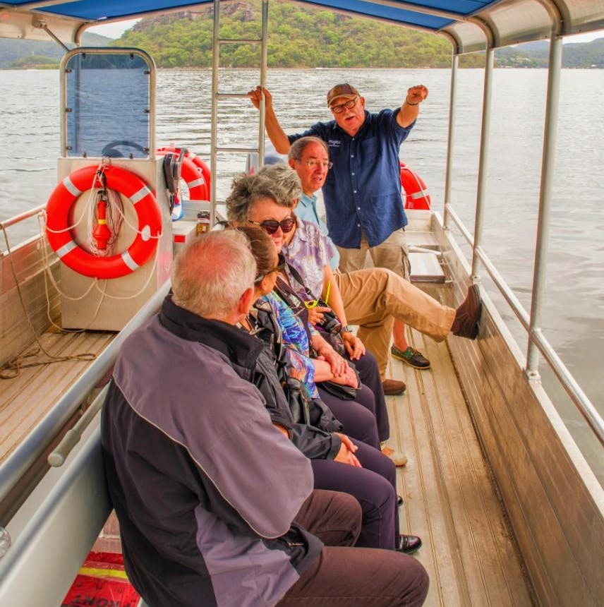 一群五名成年人坐在船上聊天，可以看到救生员，背景是风景秀丽的山景。