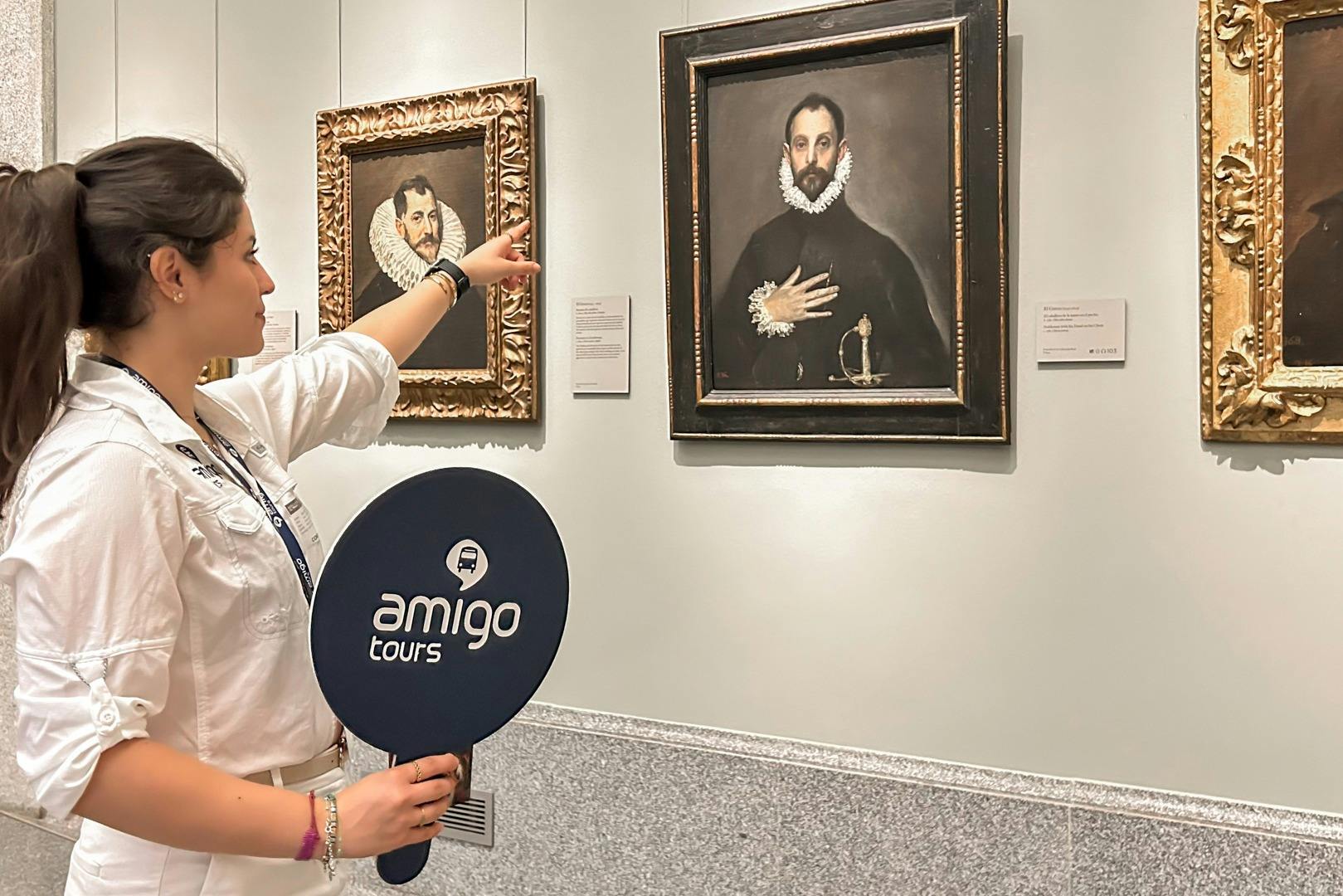 투어 가이드가 '아미고 투어' 라고 적힌 패들을 들고 박물관에 있는 그림을 가리킵니다. 근처에 또 다른 그림이 있습니다.
