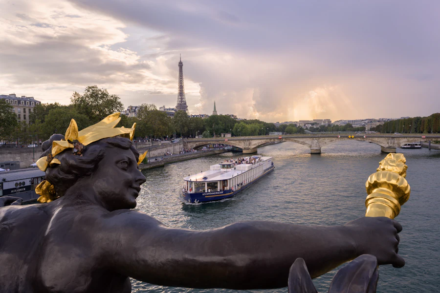 Vista de un barco para cenar en el Sena desde el Pont Alexandre III, con la Torre Eiffel al fondo