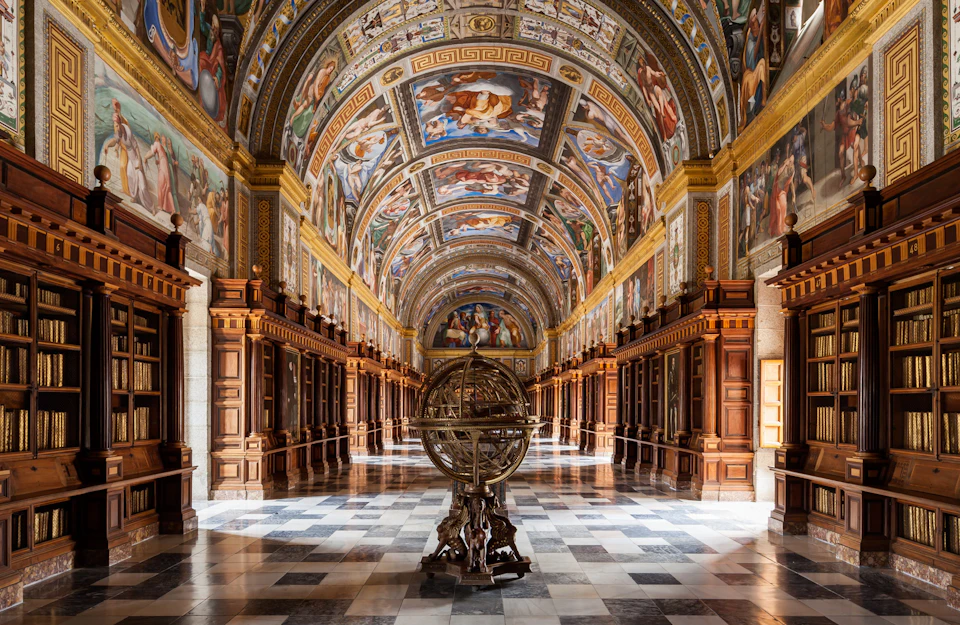 Ornate hall with frescoed ceiling, wooden cabinets along the sides, and an armillary sphere centered on a checkered marble floor.