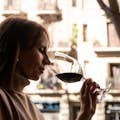 A woman holding a glass of red wine.