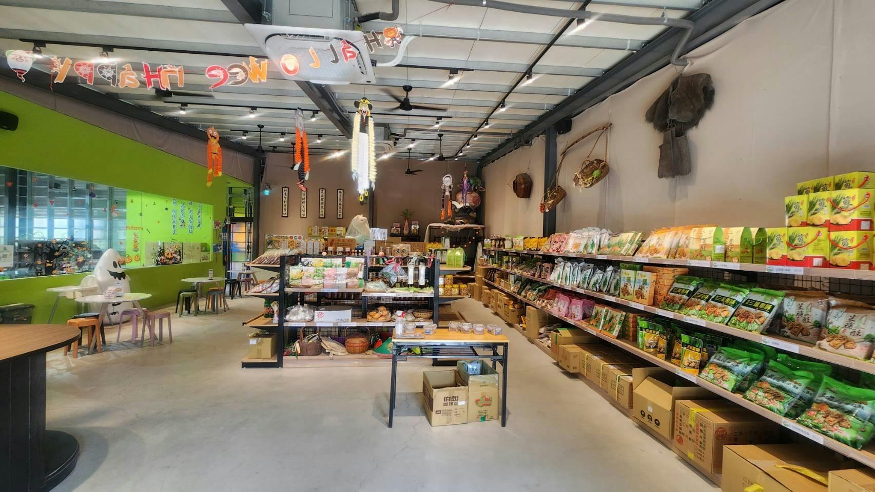 Interior of a store with shelves stocked with various packaged goods and decorations hanging from the ceiling.