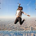 mujer saltando en la zona de la cornisa en SkyDeck chicago en lo alto de Willis Tower