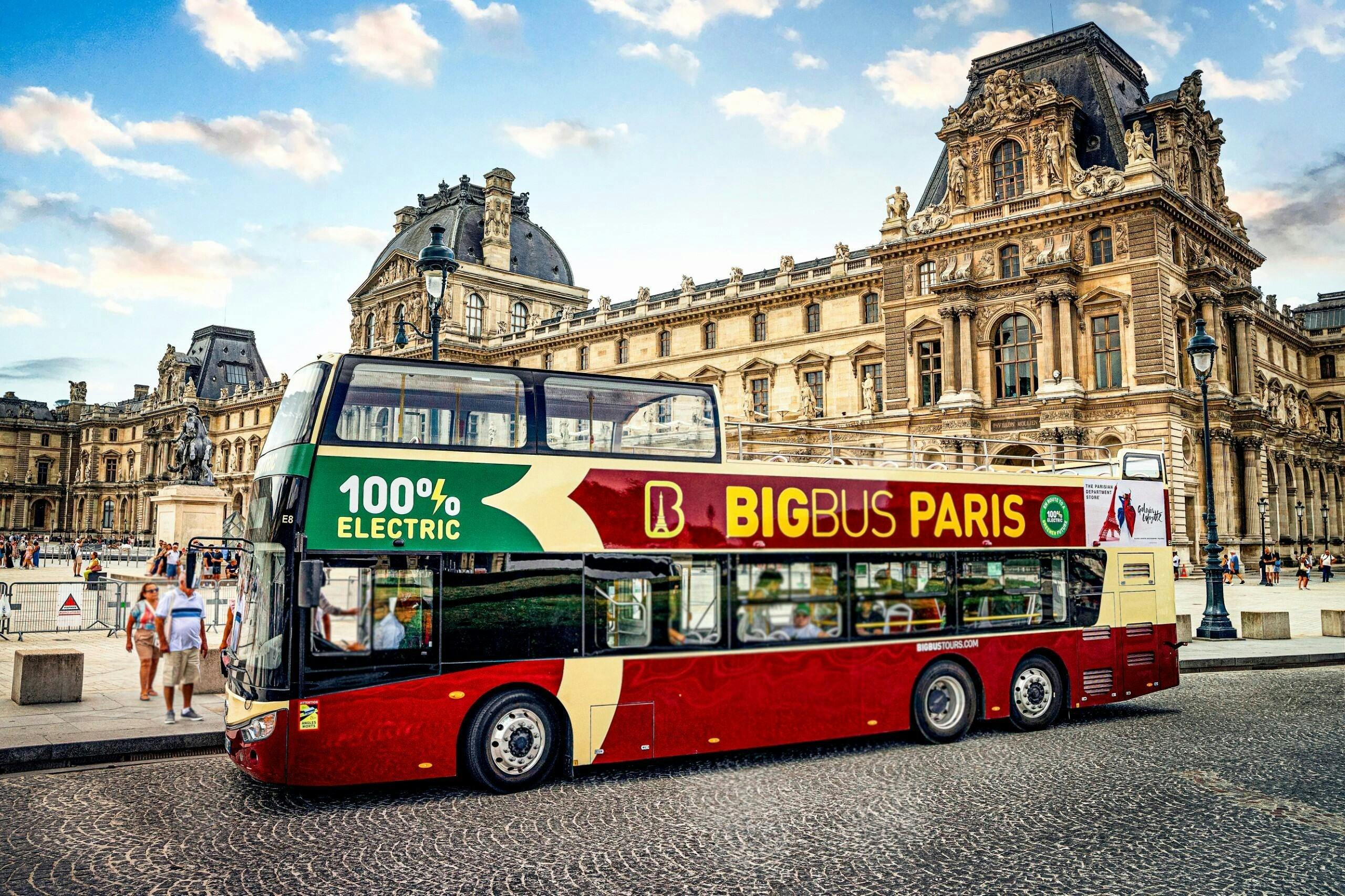 A red and yellow double-decker bus with "Big Bus Paris" and "100% electric" branding in front of a historic building.