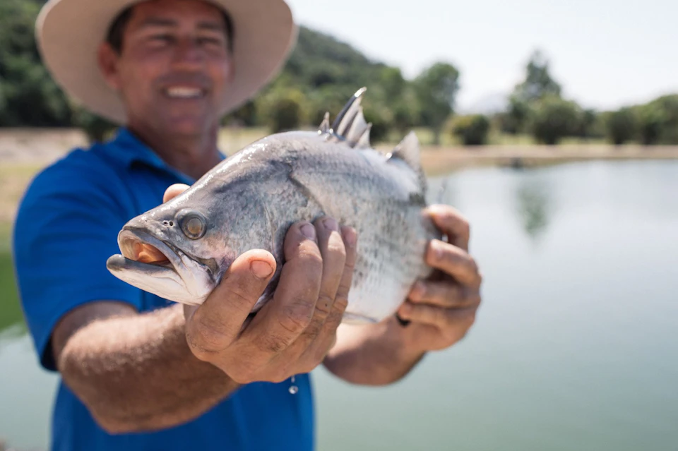 Farmer Mark holding fish.