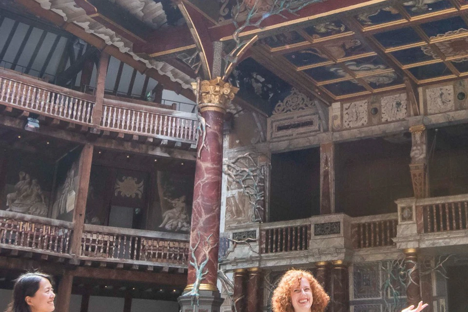 A tour group is being shown the Yard of the Globe Theatre.