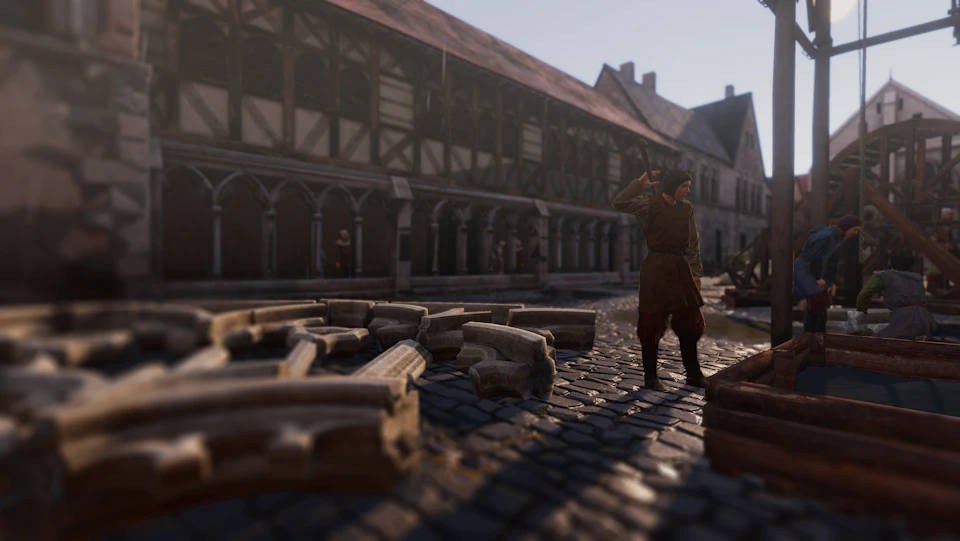 A person stands on a cobblestone street near scattered stone blocks, in front of a medieval building with wooden beams and arches.