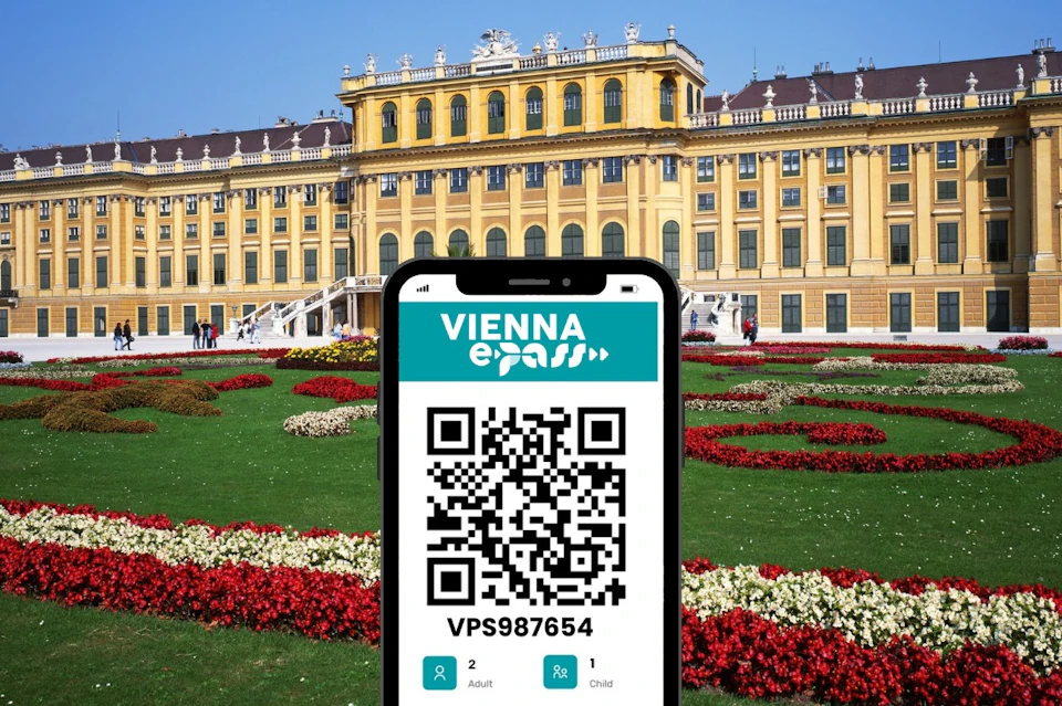 A smartphone displaying a QR code for the Vienna ePass in front of Schönbrunn Palace and landscaped gardens.