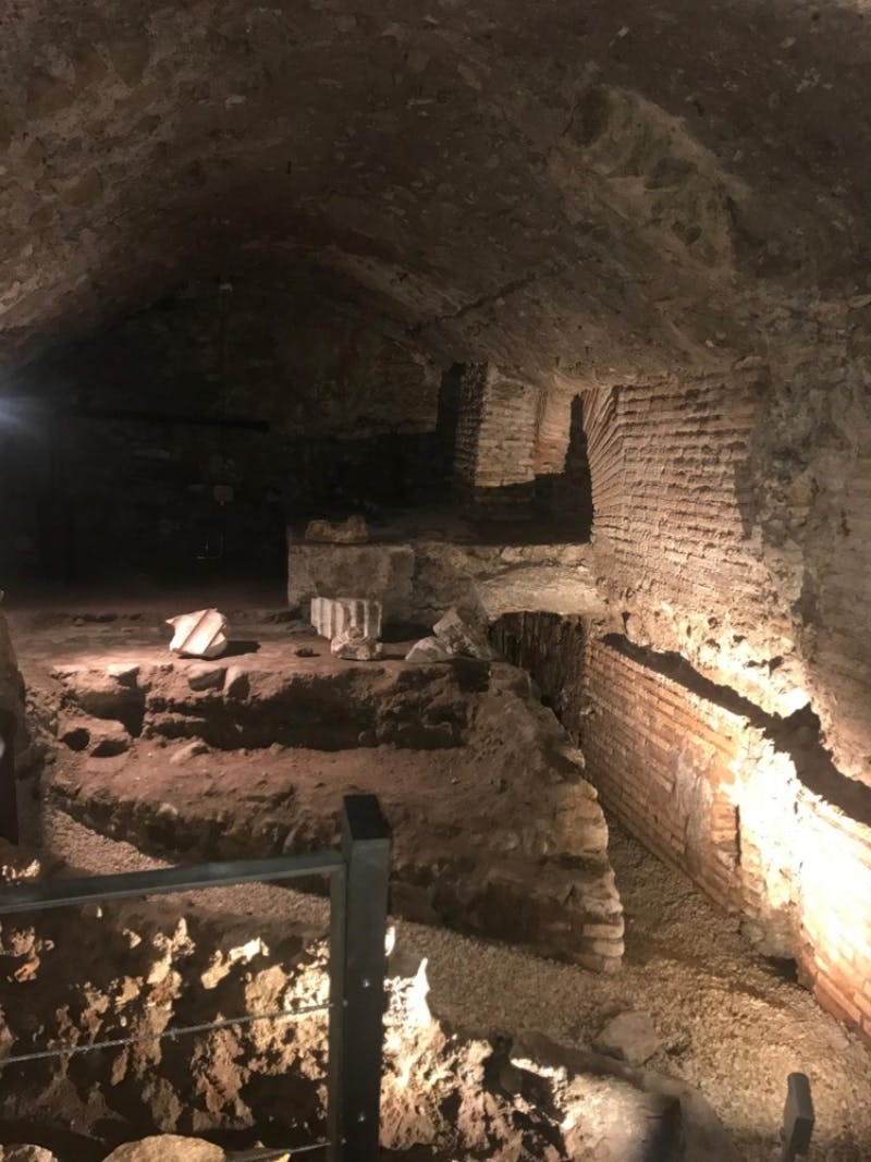 古老的地下遗迹，砖墙和石头碎片，灯光昏暗，聚光灯突出了粗糙的纹理。