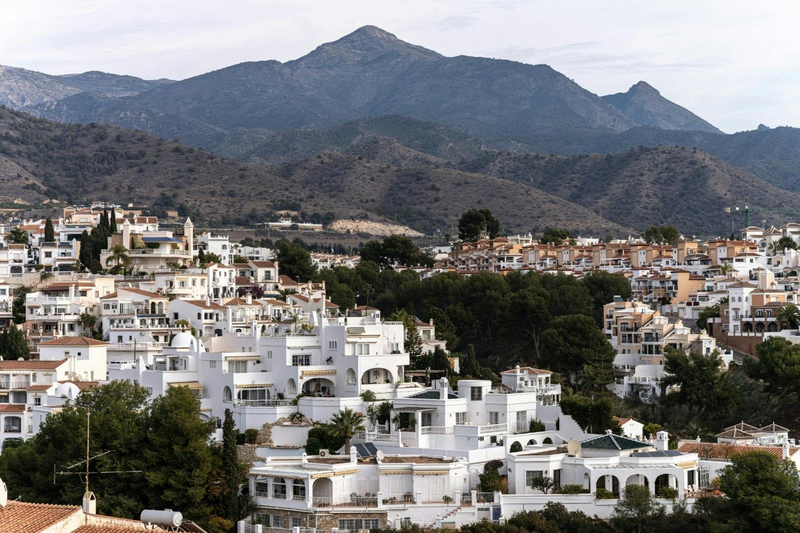 White houses with a mountain in the background, a typical Andalusian scene on the hillside.