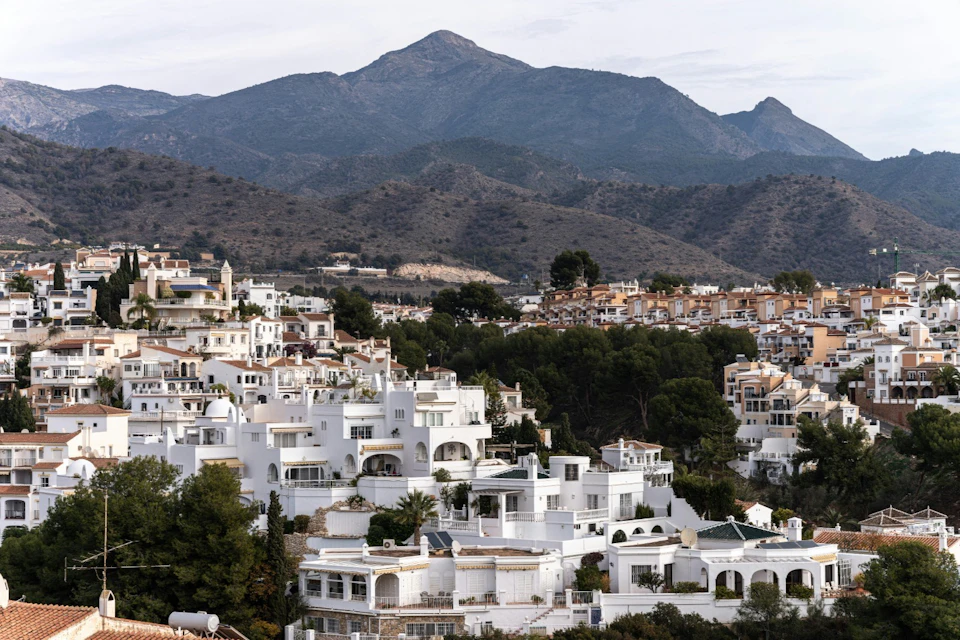White houses with a mountain in the background, a typical Andalusian scene on the hillside.