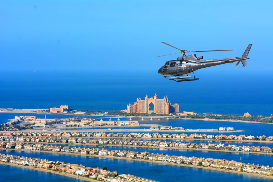 Dark Gray HeliDubai helicopter hovering over The Palm.