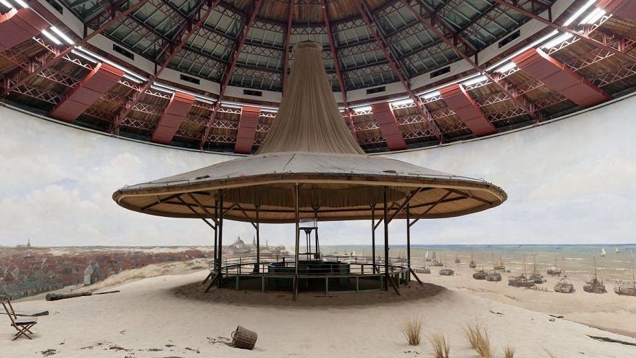 Eine runde, kuppelförmige Panorama-Ausstellung mit einer zentralen Aussichtsplattform, die von einem 360-Grad-Gemälde einer Küstenszene umgeben ist.