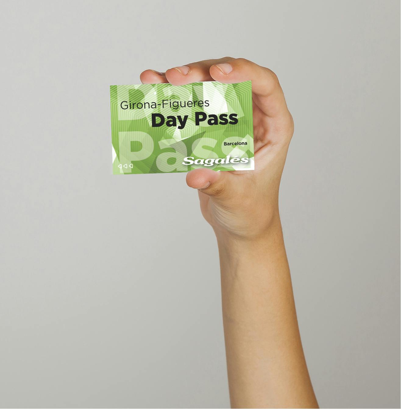 Une main tenant un billet vert de type "Girona - Figueres Day Pass, Sagalés, Barcelona" sur un fond uni.