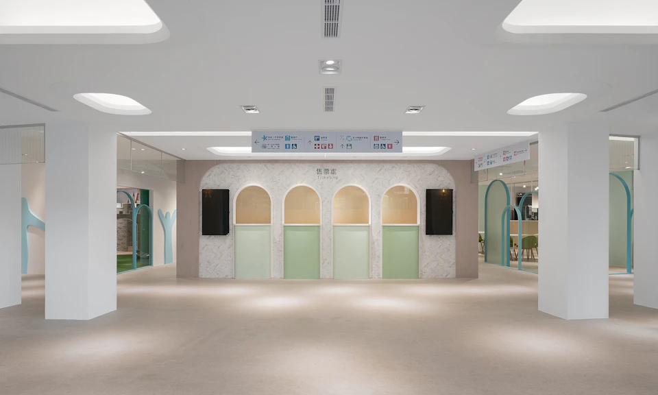 A modern interior space with white walls, arched accents, and minimalistic decor, featuring directional signs above.