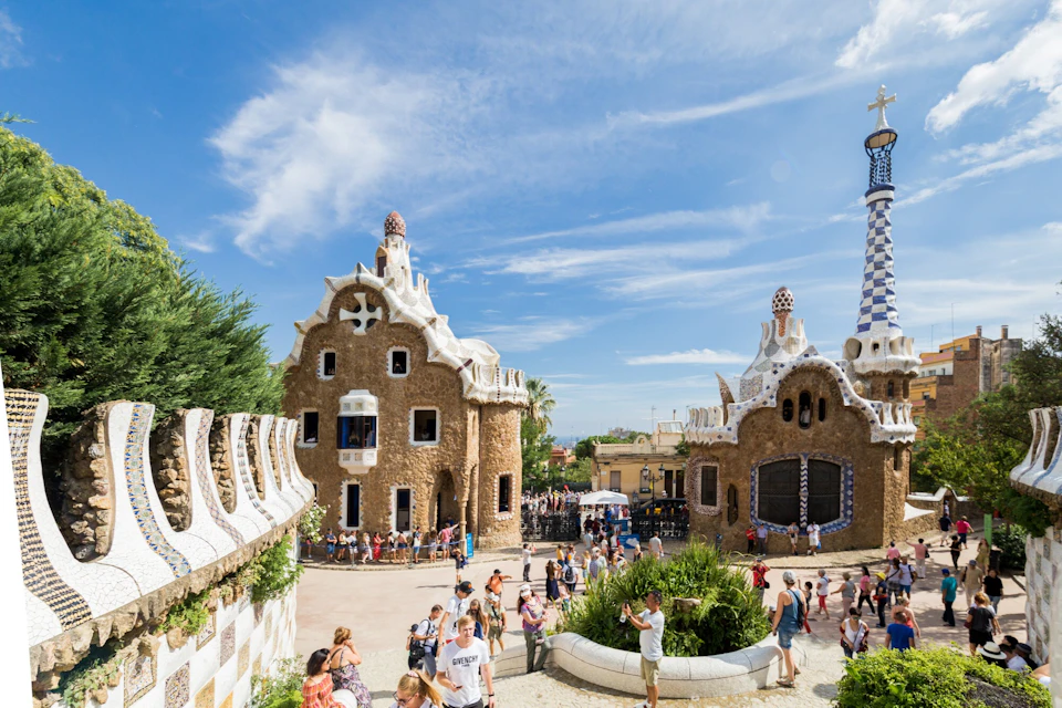 A busy tourist area featuring uniquely designed buildings with a whimsical architectural style under a blue sky.