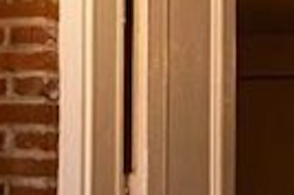 A woman in period attire stands outside a brick building near a sign reading 'The Whaley House.' The interior is warmly lit.