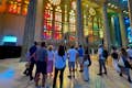 Bezoekers die de kleurrijke gebrandschilderde ramen van de Sagrada Familia van binnen bekijken.