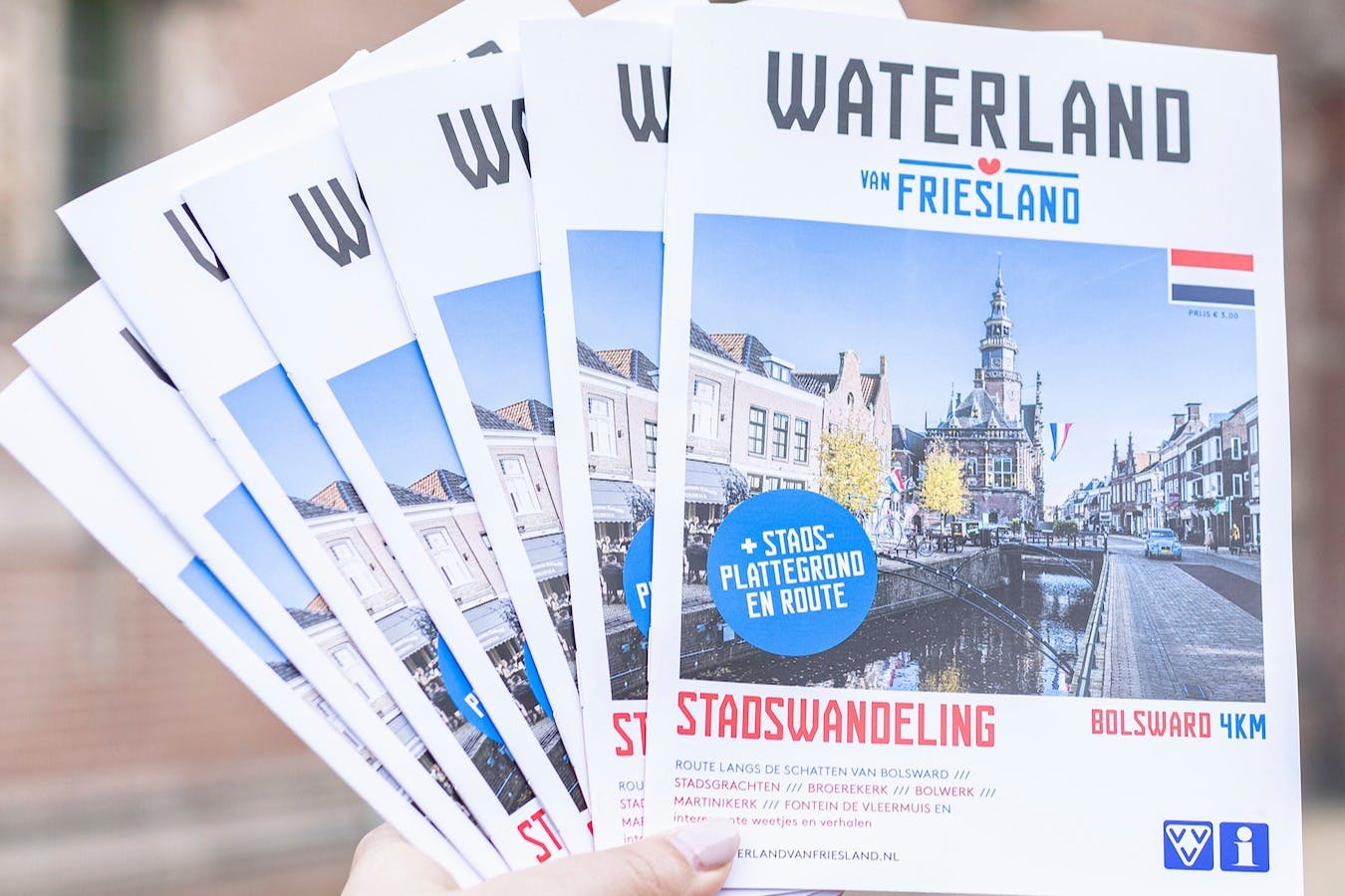 Multiple brochures for "Waterland van Friesland" with a cityscape image and text on city walks (stadswandeling) in Dutch.