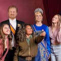 tourists posing with wax figures of the dutch royal family