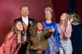 туристы позируют с восковыми фигурами голландской королевской семьи